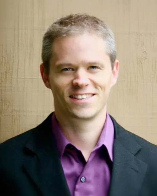 Matt Cragg in a dark jacket and purple shirt